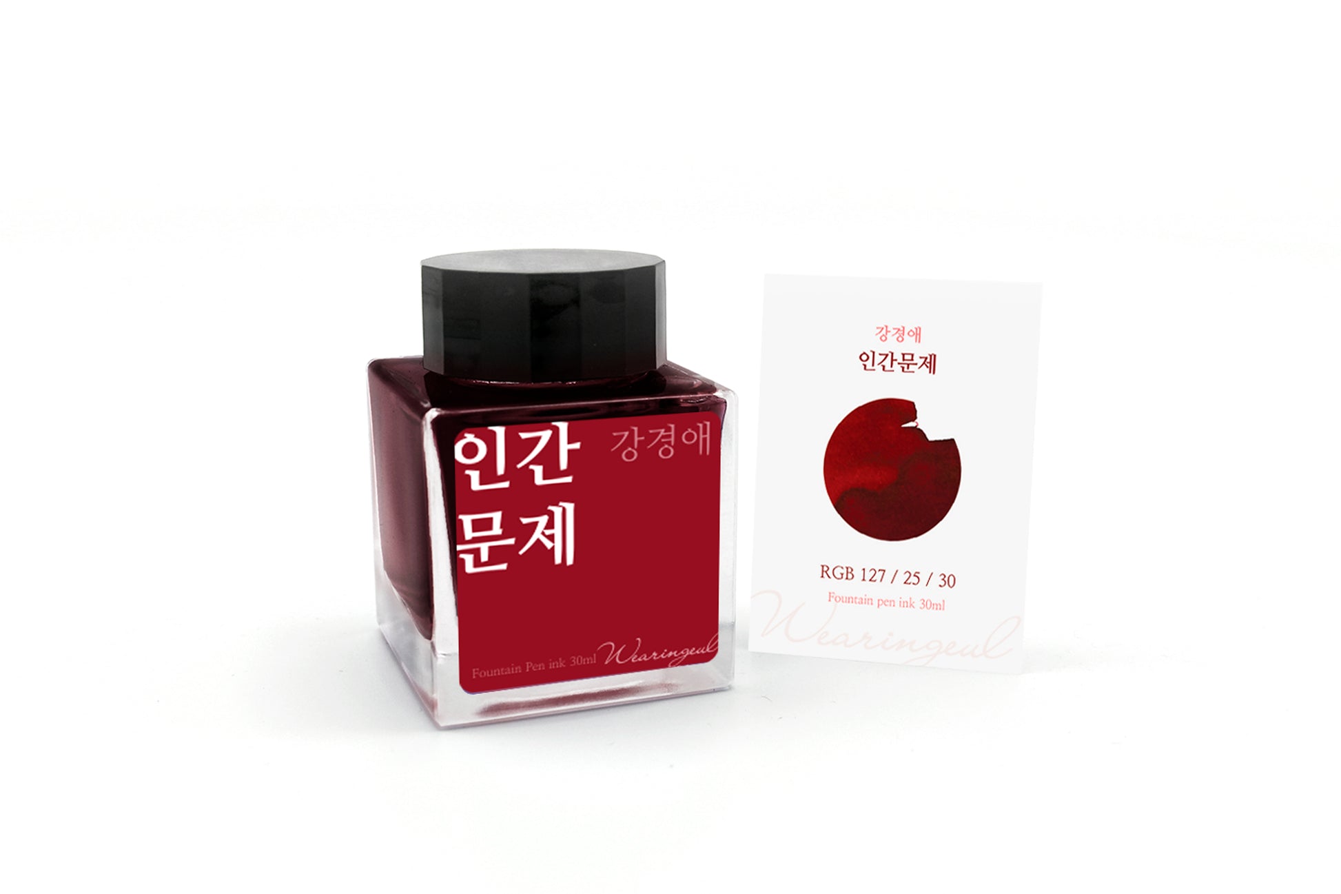 Red ink bottle with black cap and a white label on a white background